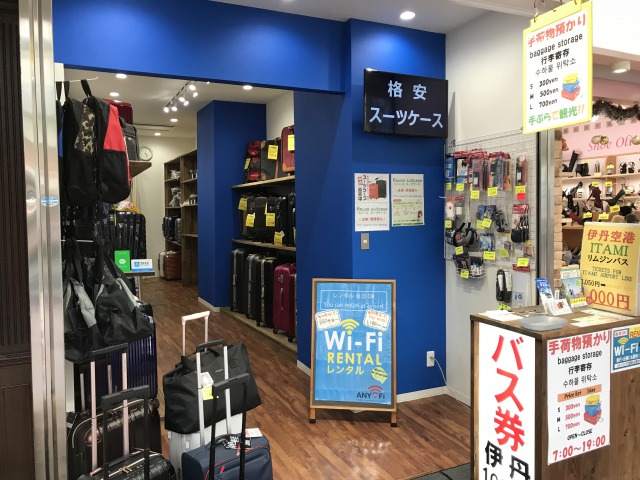 Look for the airport bus stop right in front of the shop.